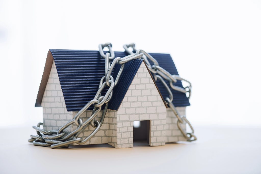 House model with metal chain isolated on white